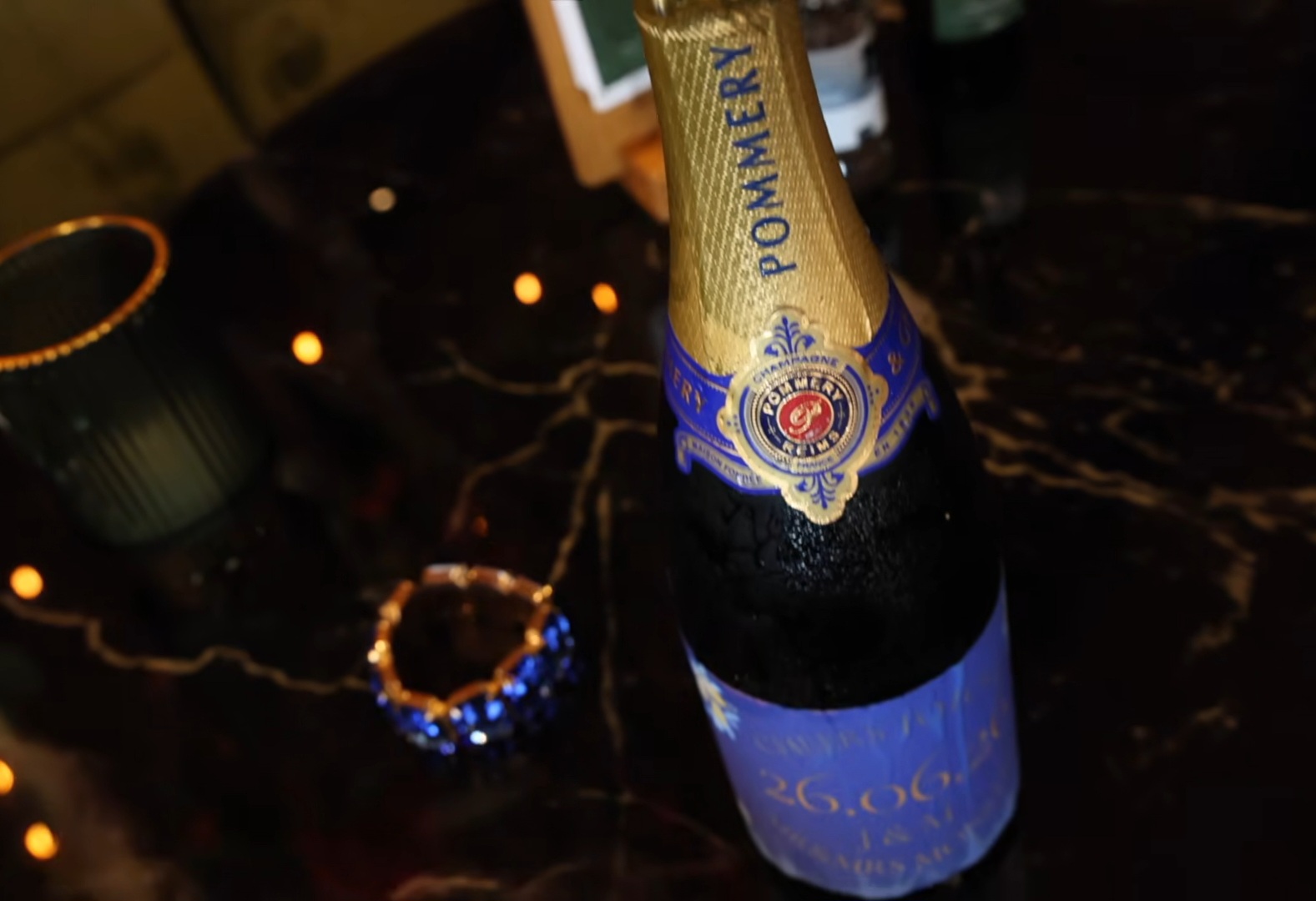 Fles champagne in sfeervol kaarslicht bij het trouwfeest